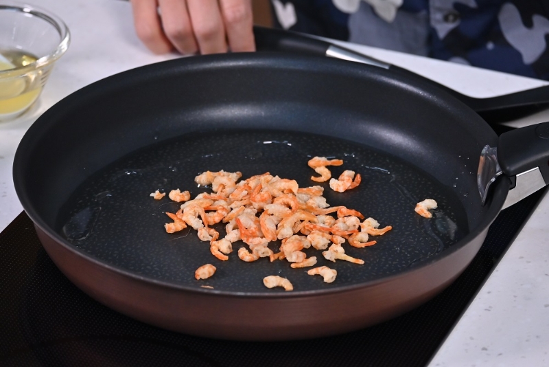 4. 起油鑊，炒香蝦米。Heat oil in a wok and fry dried shrimps until fragrant.