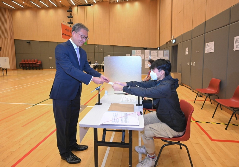 選舉管理委員會(huì)主席陸啟康法官（左）今日（十二月五日）視察位于北角社區(qū)會(huì)堂的模擬投票站，并示范2023年區(qū)議會(huì)一般選舉的正確投票程序。 圖示陸啟康法官示范使用電子選民登記冊(cè)系統(tǒng)領(lǐng)取選票。