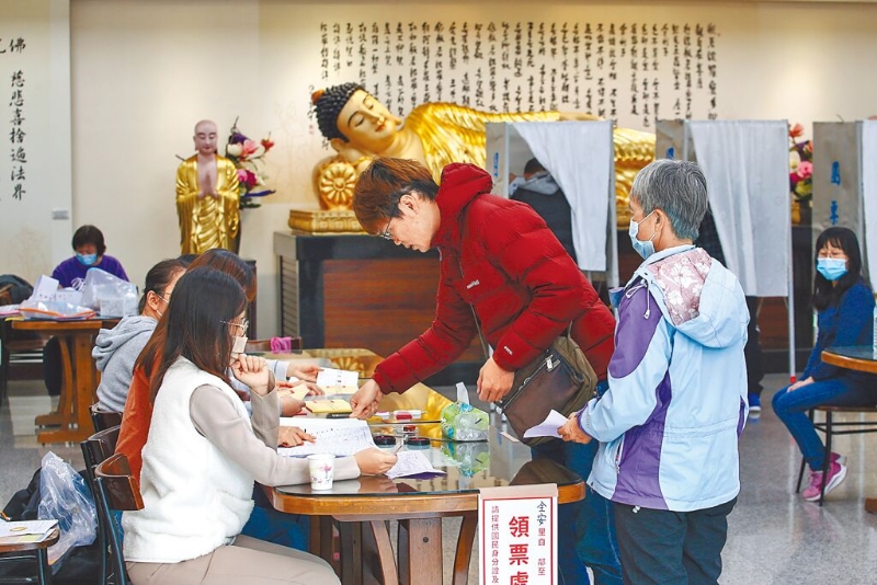 選民在新莊區佛光山擇善寺投開票所如來臥佛前投票。